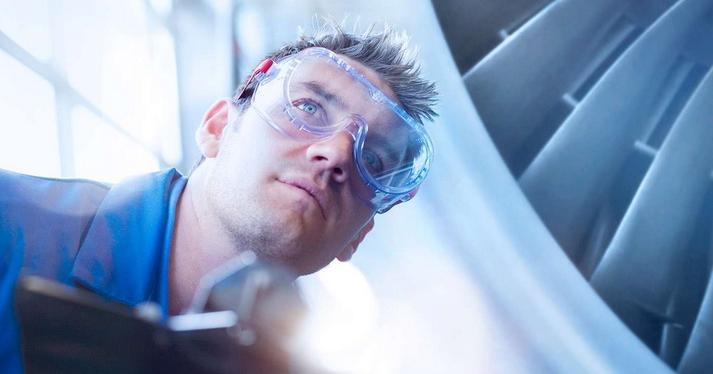 man in clear googles working on a plane